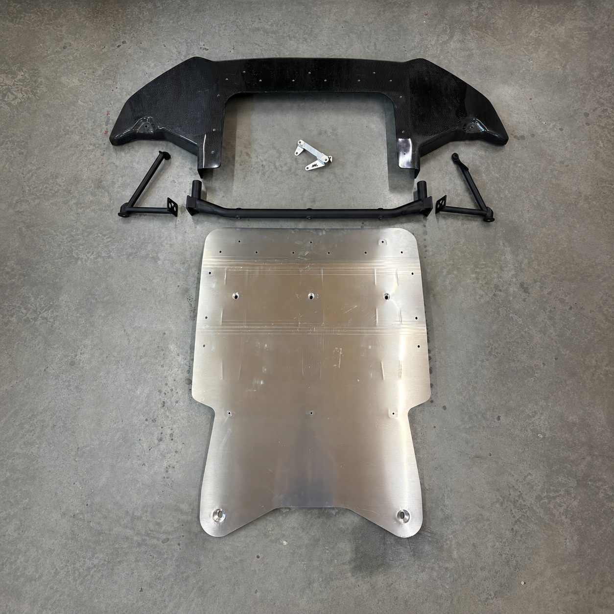 Gen2 GR Yaris Sump Guard Kit components including aluminium skid plate, steel mounting bar, composite front underguard and gearbox cooler relocation bracket